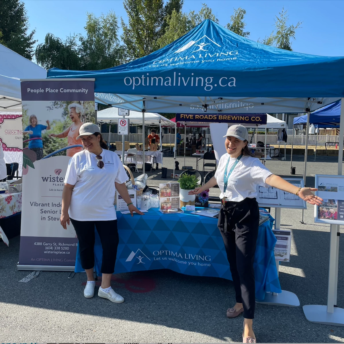 Staff members showing off the Optima Living booth at the Steveston Farmer's Market
